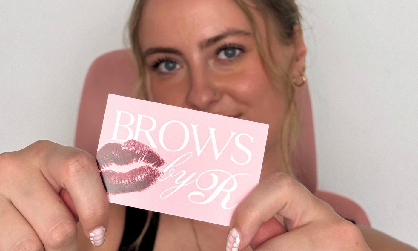 Rosie, brow artist at Brows by Rosie, holding a Brows by Rosie brand card